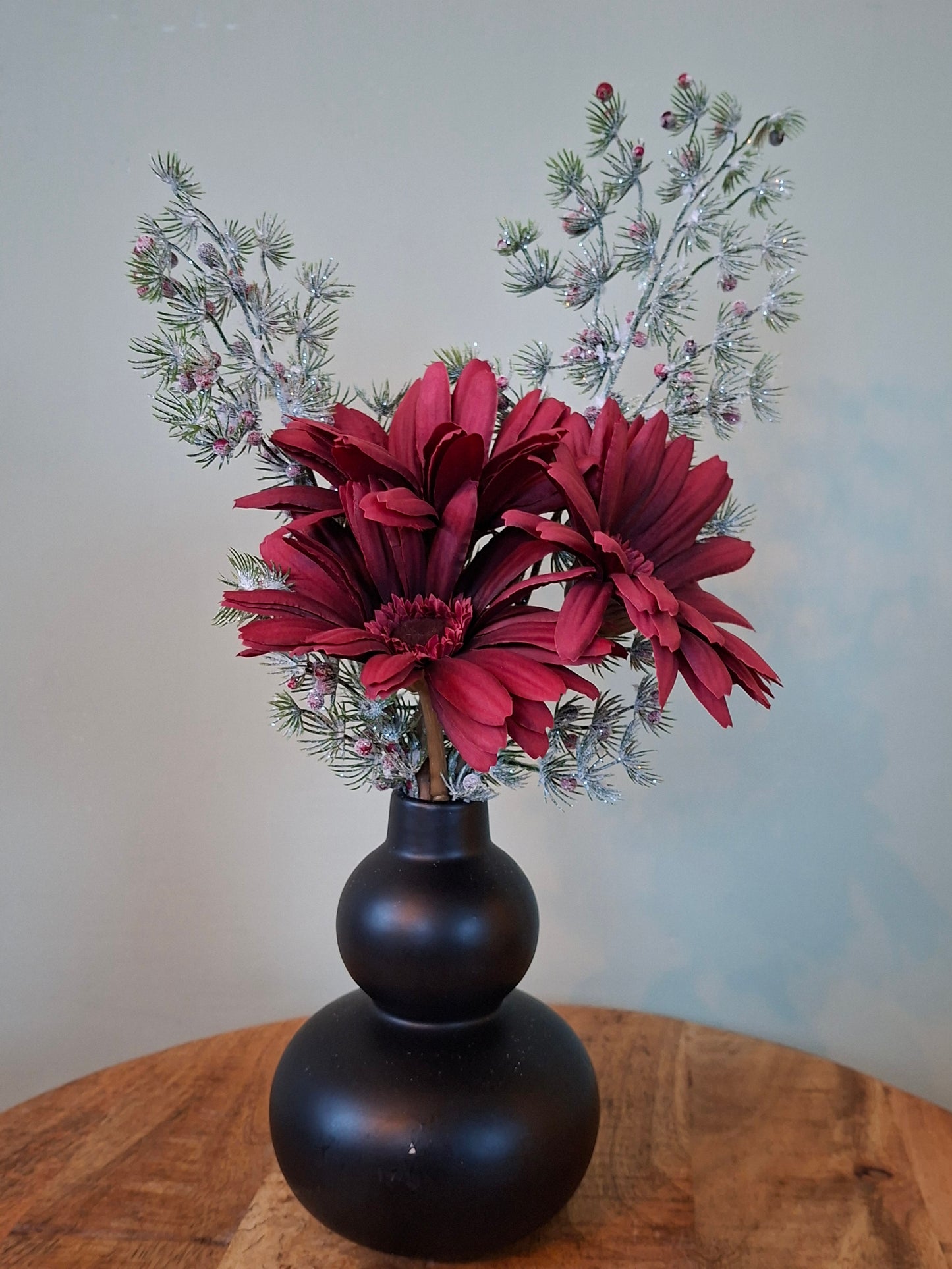 Bubbelvaas zwart met donkerrode gerbera’s en groene takjes – karaktervol woonaccent