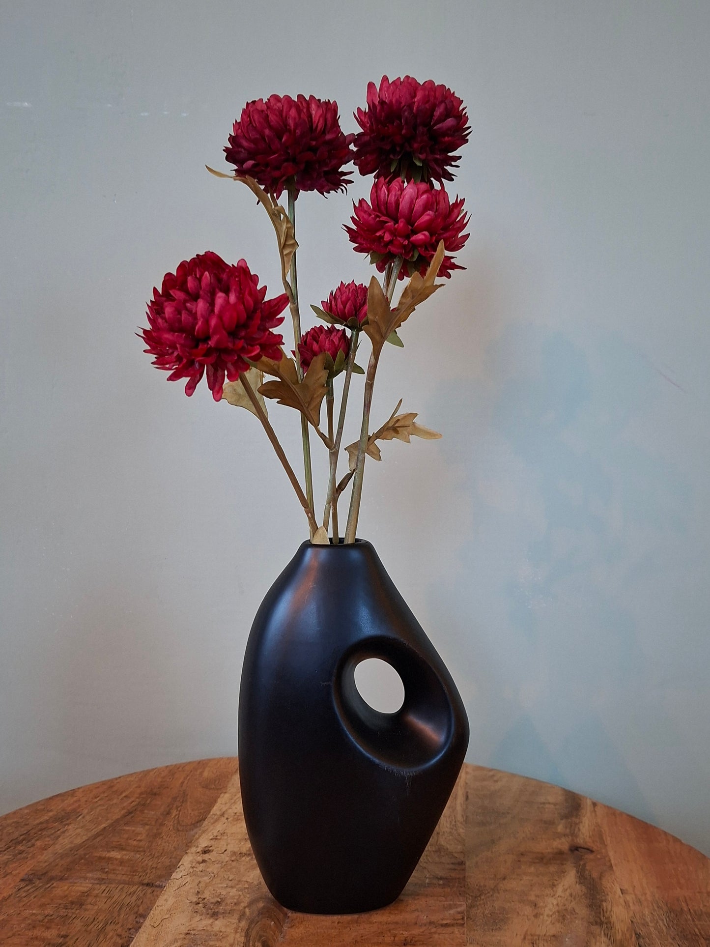 Zwarte vaas met rode bloemen – stijlvol en sfeervol woonaccent