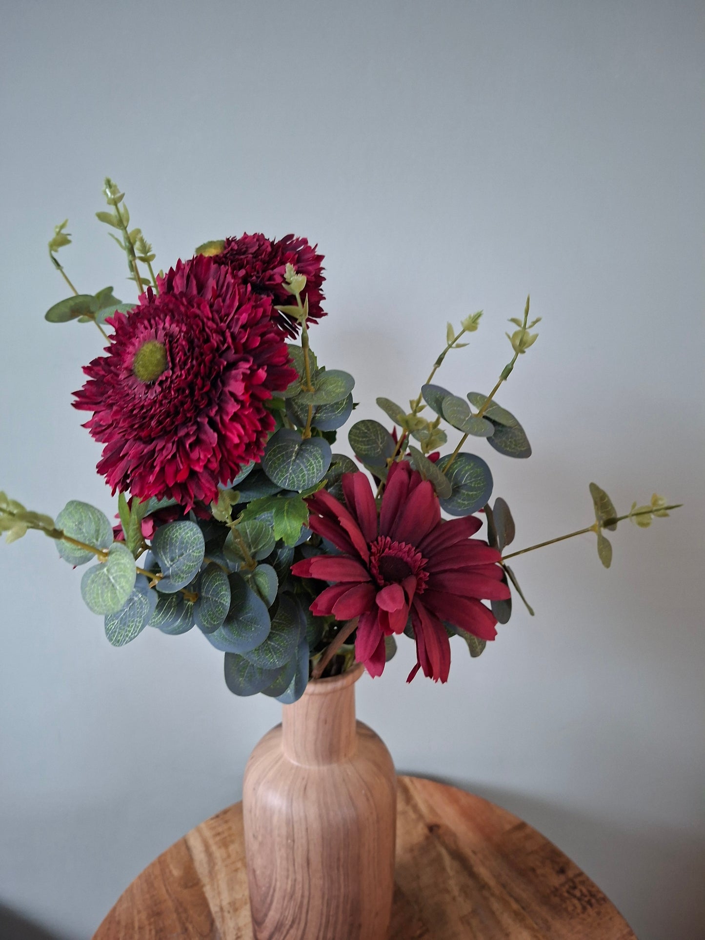 Keramieken vaas natural met houtlook – warm boeket van donkerrode gerbera’s, wilde gerbera’s en eucalyptus