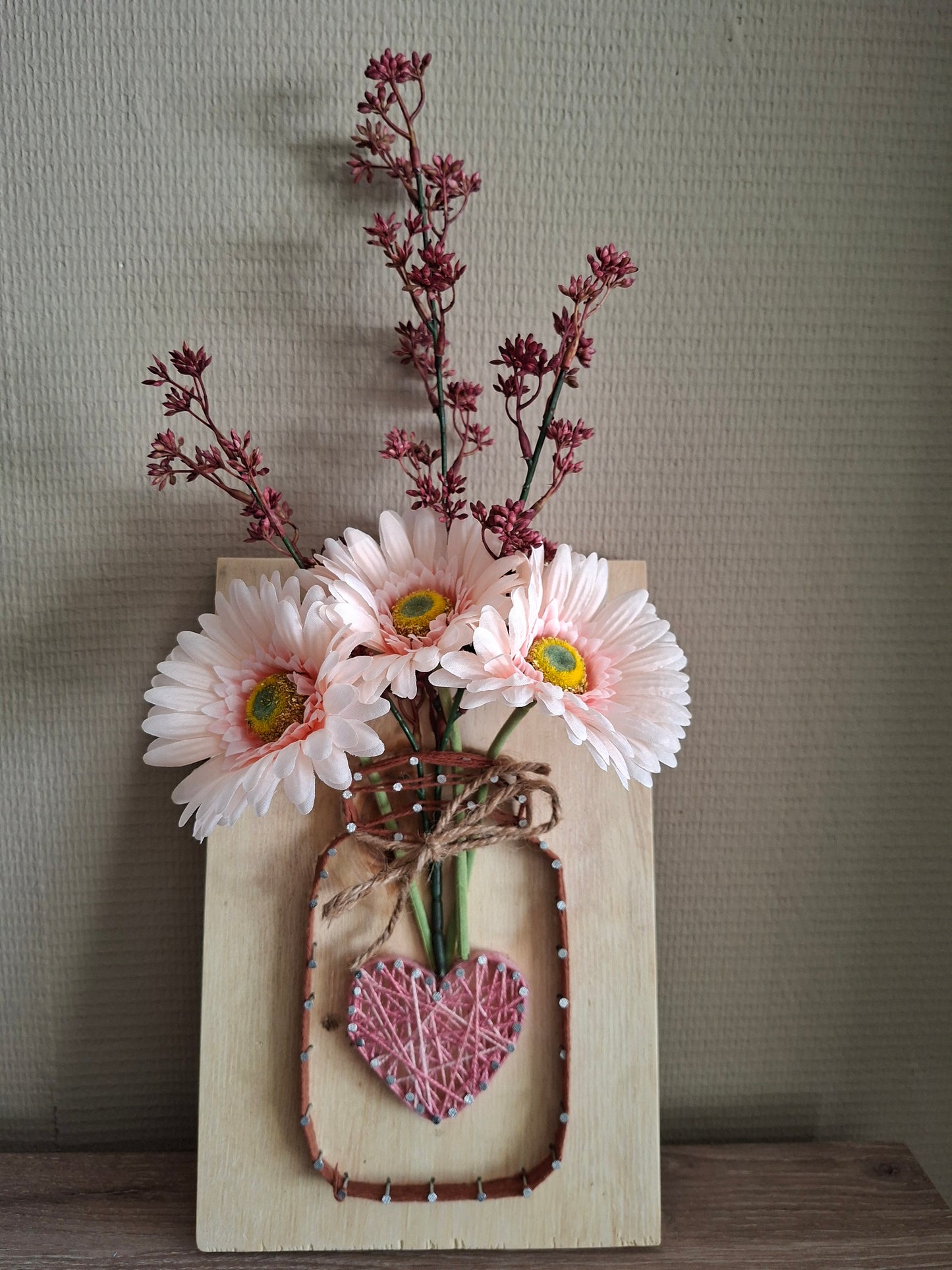 Handgemaakt bloem board met lichte roze gerbera & Prunus Rose in bruine vaas met hartje – houten wanddecoratie
