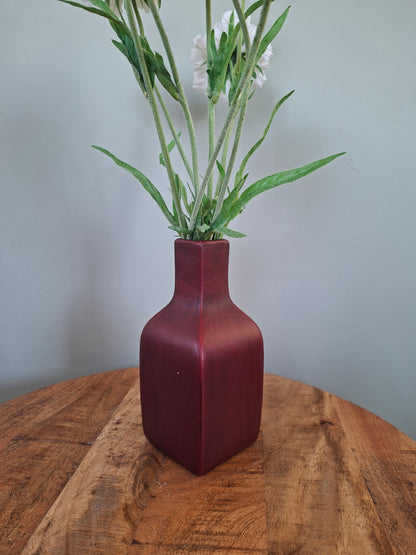 Donkerrode keramieken vaas met witte bloemen – elegant en sfeervol woonaccent